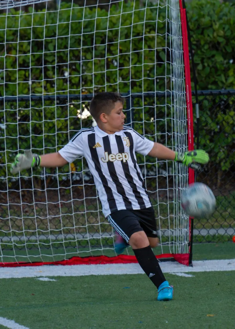 A young goalkeeper diving to save