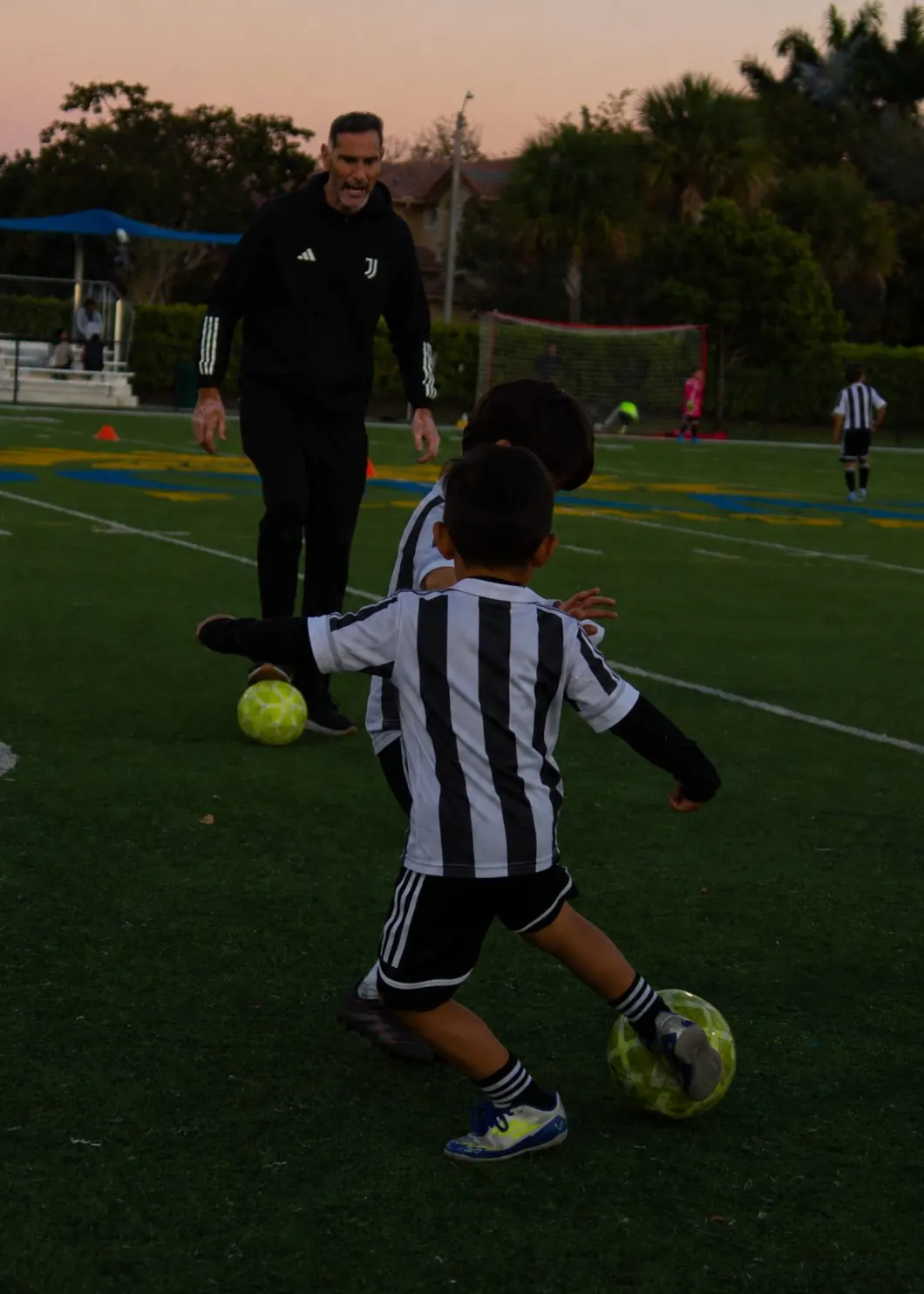 A Juventus Academy coach watching a young player dribble